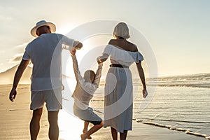 Happy family concept. Father, Mother and son having fun together on summer, sunset beach