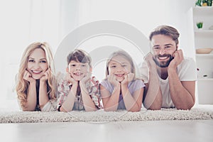 Happy family concept. Four relatives are lying on the carpet on