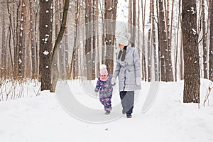 Happy family concept - Mother and child girl on a winter walk in nature.