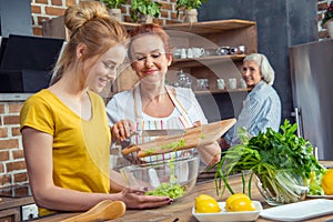 Happy family cooking together vegetable salad