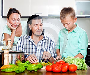 Happy family cooking veggy lunch