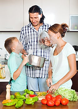 Happy family cooking veggy lunch