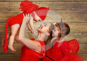 Happy family with costumes devil prepares for Halloween