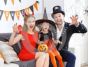 Happy family in costumes getting ready for halloween at home