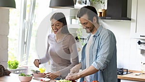 Happy family couple enjoying cooking healthy food.