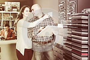 Happy family couple looking at kitchen facade in furniture works