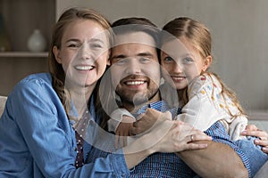 Happy family couple of parents and sweet daughter kid hugging