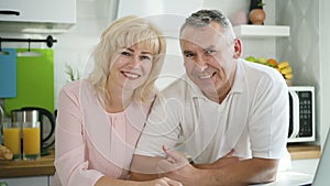 Happy family couple posing for photo in modern kitchen.