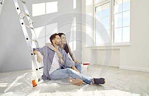 Happy family couple relaxing on floor while doing renovations in their house or apartment