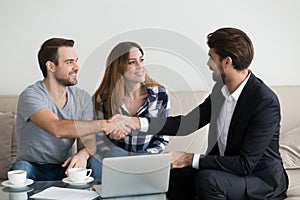 Happy family couple renters tenants handshaking realtor landlord at meeting