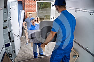 Happy Family Couple Watching Movers Unload Furniture photo