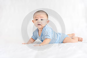 Happy family, Cute Asian newborn baby wear blue shirt lying, crawling, play on white bed