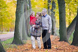 Happy family with cute toddler girl walking in park