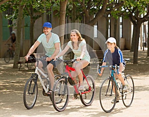 Happy family cycling in park togetherness