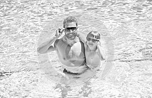 happy family of dad and child having fun in summer swimming pool, happiness