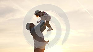 Happy family dad and little daughter are playing in park. Dad throws up a happy daughter in blue sky. Father and child