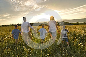 Famiglia felice sul margherita sul tramonto con il grande comune 