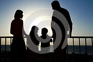 Happy family at the dawn of the sea silhouette background