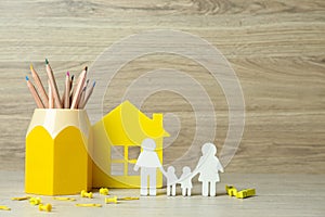 Happy Family Day. Figures of parents, their children, house and stationery on table, space for text