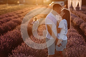 happy family day. young father, mother and child daughter are having fun together in the lavender field on sunset. happy