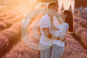 happy family day. young father, mother and child daughter are having fun together in the lavender field on sunset. happy