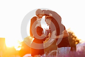 happy family day. Young mother and father carrying on shoulders daughter in lavender field on sunset. Dad, mom and child