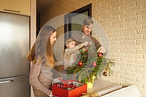 Happy family decorating a Christmas fir branches.