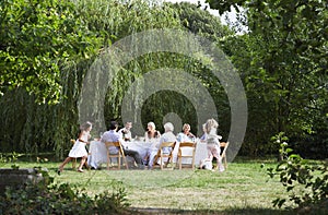 Happy Family Dining Together In Garden photo