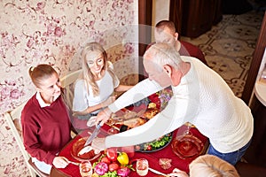 Happy family at the dinner table celebrating Thanksgiving on a blurred background. Traditional Thanksgiving concept.