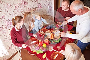 Happy family at the dinner table celebrating Thanksgiving on a blurred background. Traditional Thanksgiving concept.