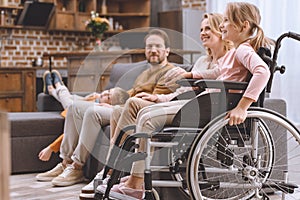 happy family with disabled little daughter in wheelchair spending time together