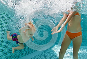 Happy family dive underwater with fun in swimming pool