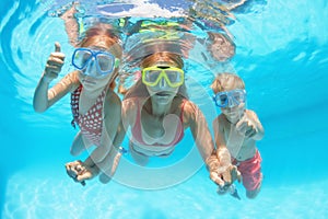 Happy family dive underwater with fun in swimming pool