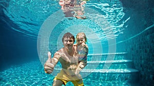 Happy family dive underwater with fun in swimming pool