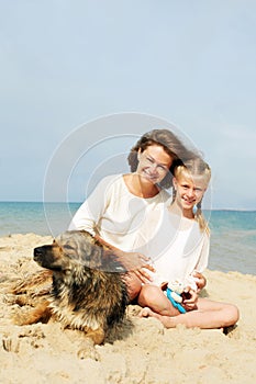 Happy family with dog on the beach