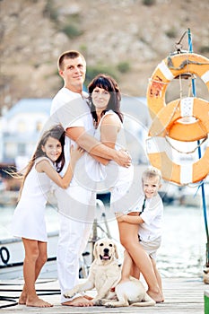Happy family with dog on berth in summer photo