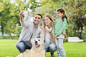 Happy family with dog taking selfie by smartphone