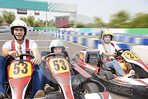 Happy family driving go kart on the track