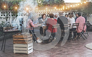 Happy family eating at barbecue party dinner - Different age of people having fun at bbq meal sitting in villa backyard - Summer