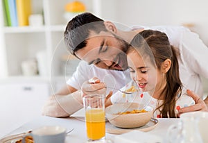 Happy family eating flakes for breakfast at home