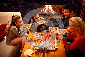 Happy family eating pizza slices for the dinner