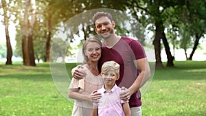 Happy family embracing and looking at camera, social insurance, protection