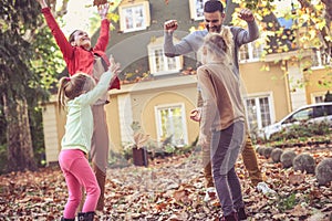 Happy family enjoy in autumn season at front of their backyard.