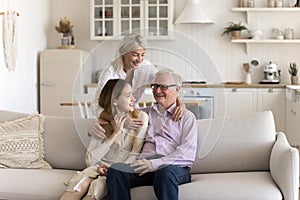 Happy family enjoy conversation sitting on sofa in living room