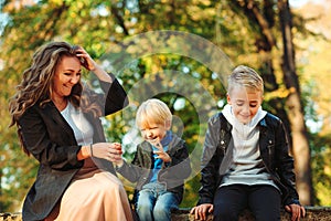 Happy family enjoying autumn. Mother with children walking in autumn park. Autumn vacation