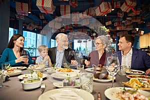 Happy family enjoying Christmas dinner together and toasting