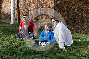 A happy family enjoying a day in the park together sitting on the grass