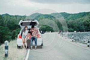 Happy family enjoying road trip and summer vacation with mountain background