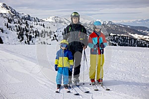 Happy family, enjoying ski holiday with children, sunny beautiful weather