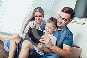 Family enjoying together at home, using tablet and having great time together